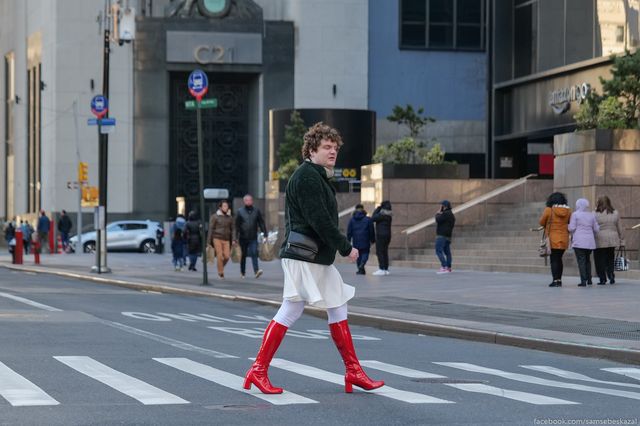 a person in tall red boots crosses a Manhattan street